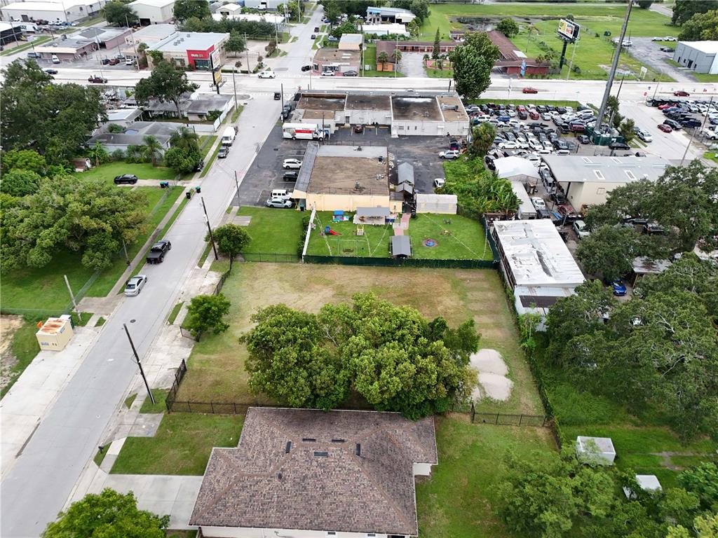 An aerial view shows a residential lot with a house, trees, and adjacent commercial buildings — 1221 25TH STREET, ORLANDO, FL