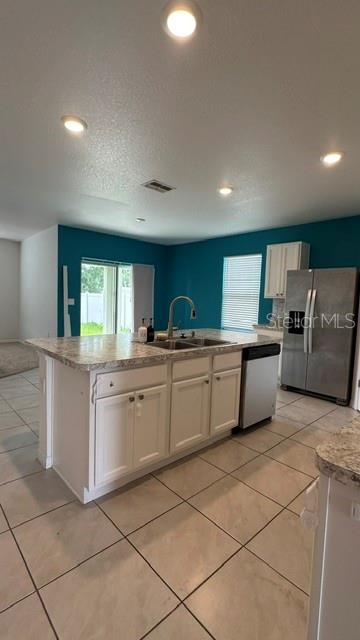 A kitchen features a white island with a granite countertop, stainless steel appliances, and teal walls — 494 JACKS WAY, DAVENPORT, FL