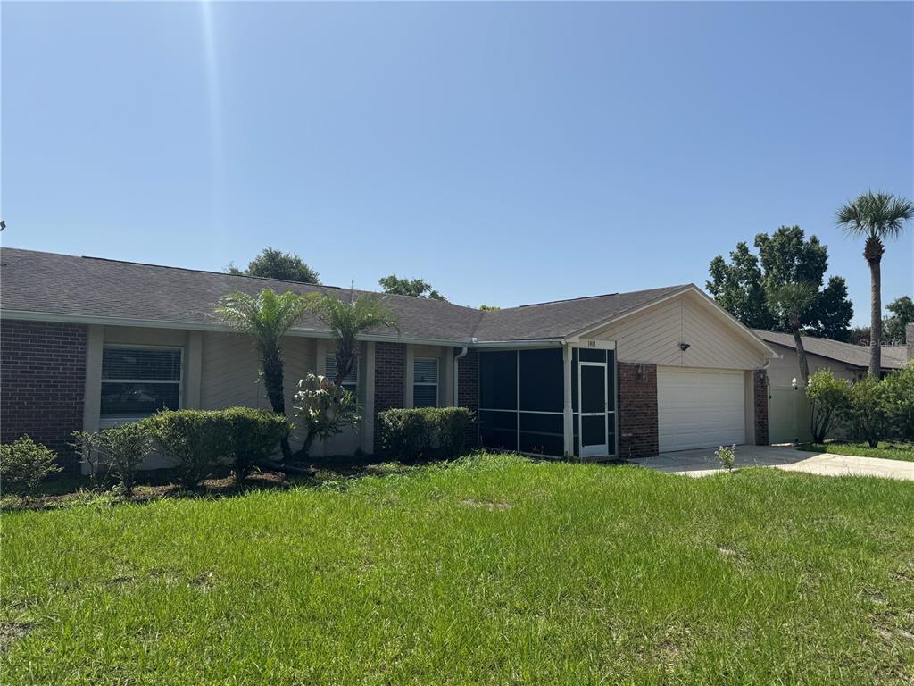 A single-story brick and siding house with a screened front porch and two-car garage — 1401 ASTER COURT, WINTER PARK, FL
