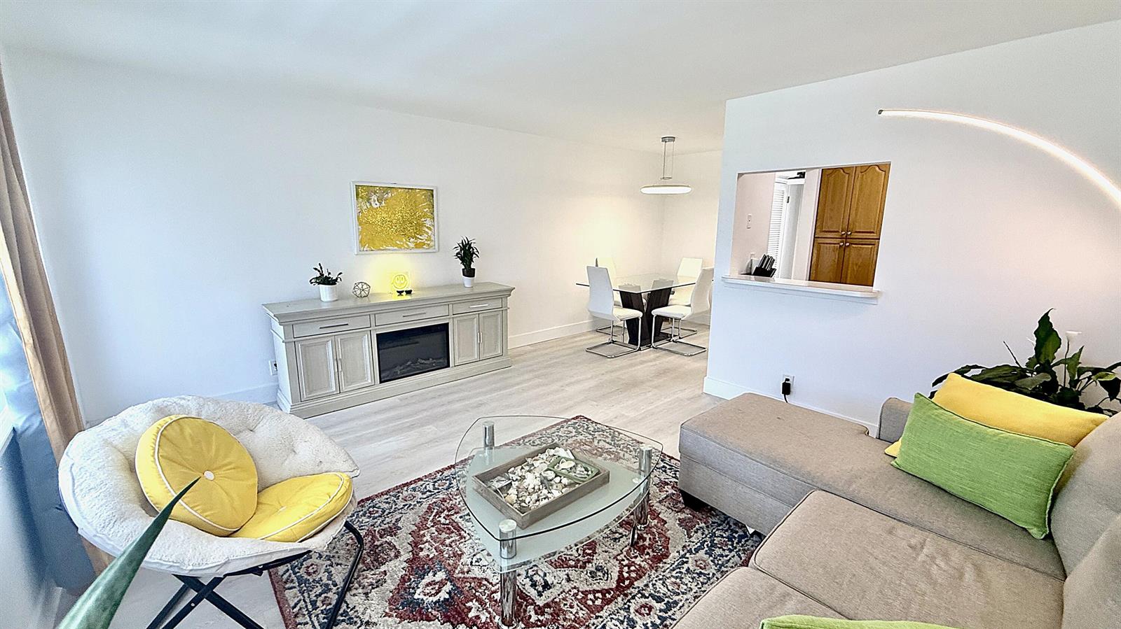 A living room and dining area feature light wood flooring, white walls, and modern furniture — 78 Harwood H Crescent, Deerfield Beach FL 33442, DEERFIELD BEACH, FL