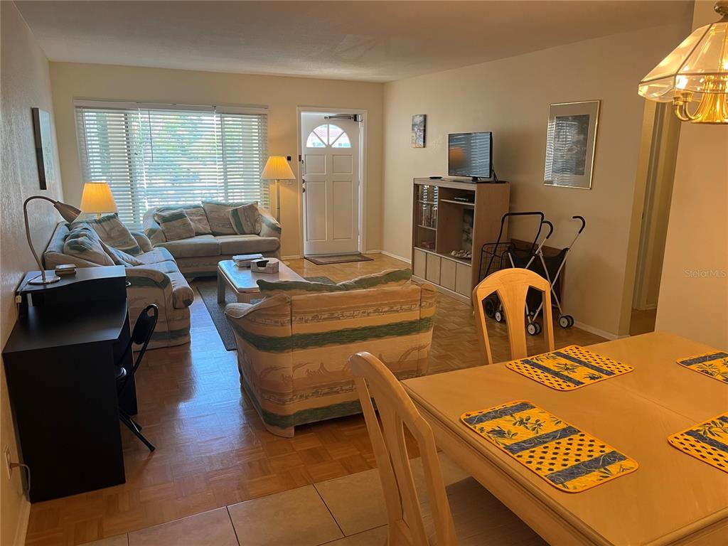 A kitchen features dark wood cabinets, white appliances, a tiled backsplash, and light floor tiles — 2071 AUSTRALIA WAY W UNIT 29, CLEARWATER, FL