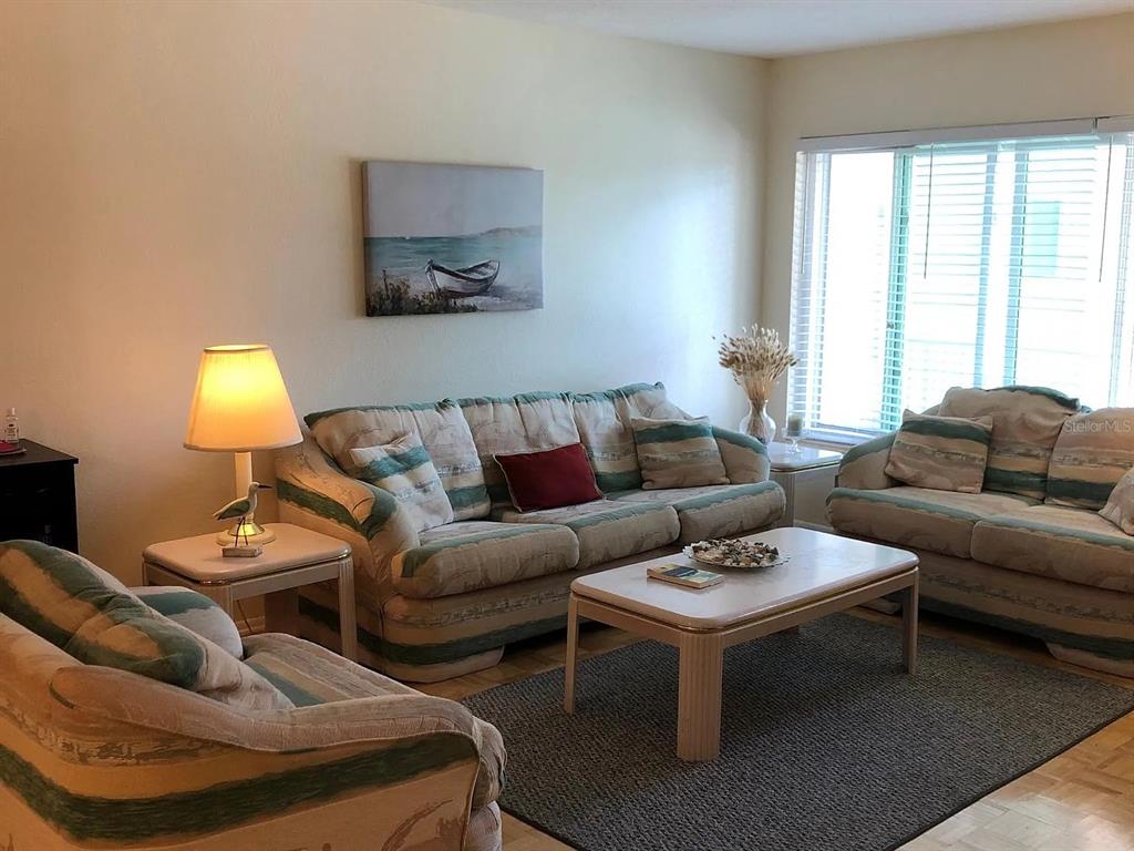 A bedroom features a large bed with a blue comforter, a dresser, and two mirrors — 2071 AUSTRALIA WAY W UNIT 29, CLEARWATER, FL