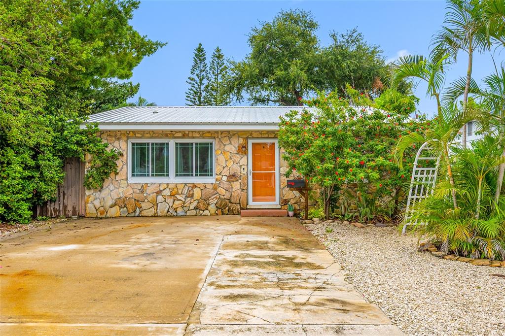 A single-story house with a stone facade, metal roof, and a concrete driveway — 3935 11TH AVENUE N, ST PETERSBURG, FL