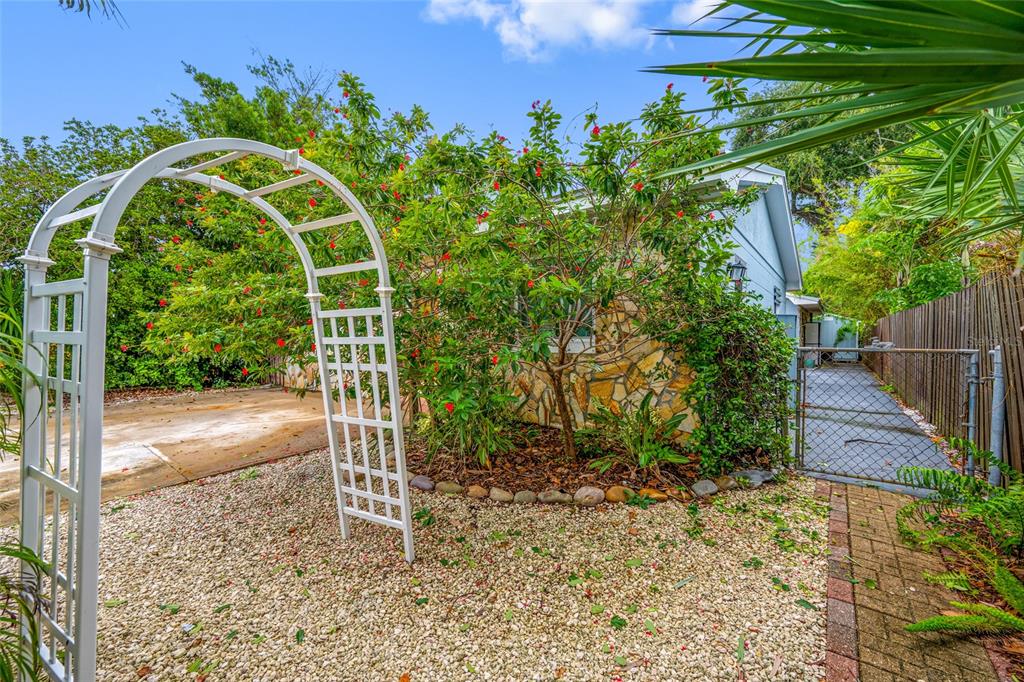 A living room features a drum set, exercise bike, patterned armchairs, and a built-in bookshelf — 3935 11TH AVENUE N, ST PETERSBURG, FL