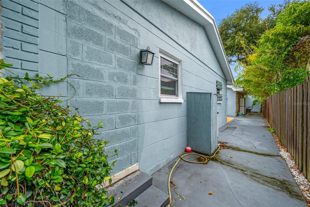 A living room features light gray walls, terrazzo flooring, floral armchairs, and musical instruments — 3935 11TH AVENUE N, ST PETERSBURG, FL