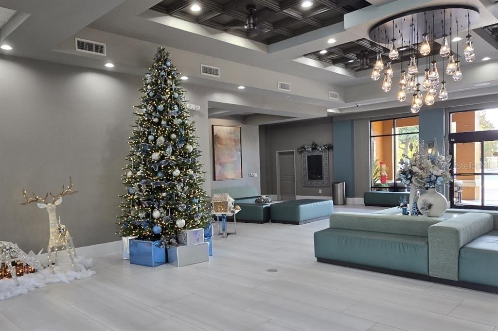 A spacious lobby features a large Christmas tree, modern seating, and a decorative chandelier — 12556 FLORIDAYS RESORT DRIVE UNIT A-201, ORLANDO, FL