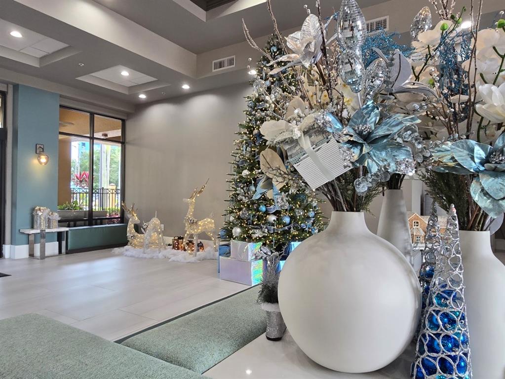 A lobby decorated for the holidays features a Christmas tree, light-up reindeer, and floral arrangements — 12556 FLORIDAYS RESORT DRIVE UNIT A-201, ORLANDO, FL