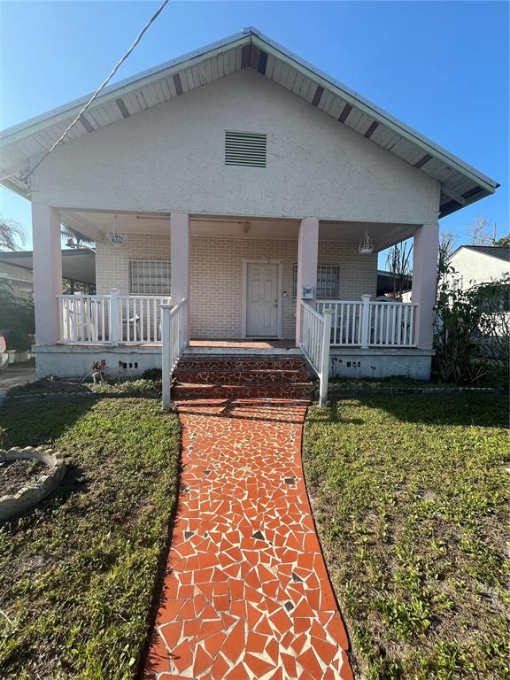 A single-story house features a covered front porch with a mosaic-tiled walkway — 2405 CORRINE STREET, TAMPA, FL