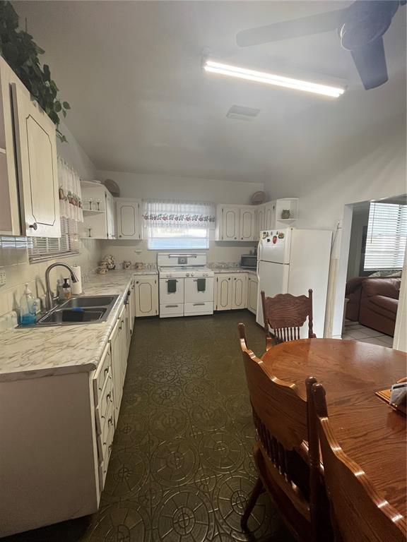 A kitchen features white cabinets, a patterned floor, a dining table, and a ceiling fan — 2405 CORRINE STREET, TAMPA, FL