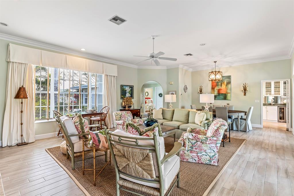 A bright living room features light green walls, floral-patterned armchairs, and a dining area — 252 WATERWAYS AVENUE, BOCA GRANDE, FL