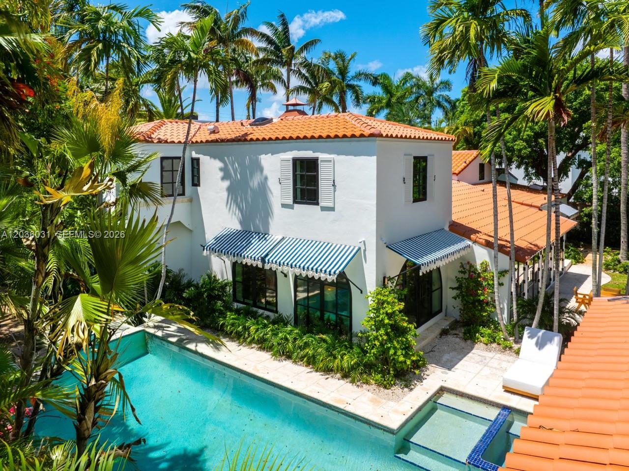 An exterior view of a two-story white house with a pool, spa, and palm trees — 4727 N Bay Rd, Miami Beach FL 33140, MIAMI BEACH, FL
