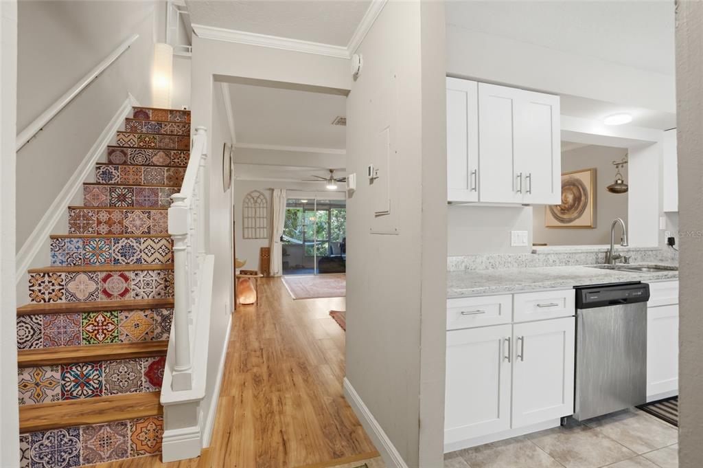 A view from a kitchen looking toward a staircase with patterned risers and a living area — 504 GREEN SPRING CIRCLE, WINTER SPRINGS, FL