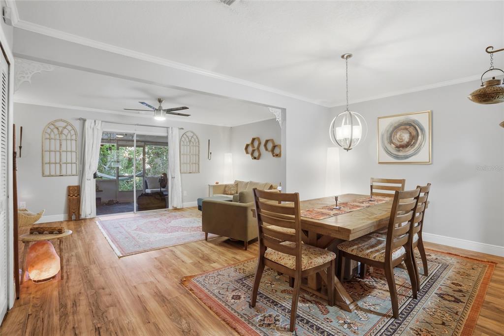 A dining area with a wooden table and chairs flows into a living room space — 504 GREEN SPRING CIRCLE, WINTER SPRINGS, FL