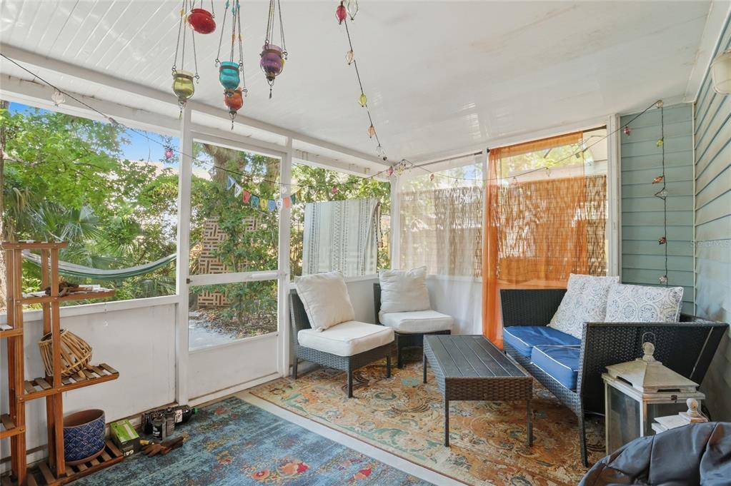 A screened-in porch features wicker furniture, a patterned area rug, and hanging decorative lanterns — 504 GREEN SPRING CIRCLE, WINTER SPRINGS, FL