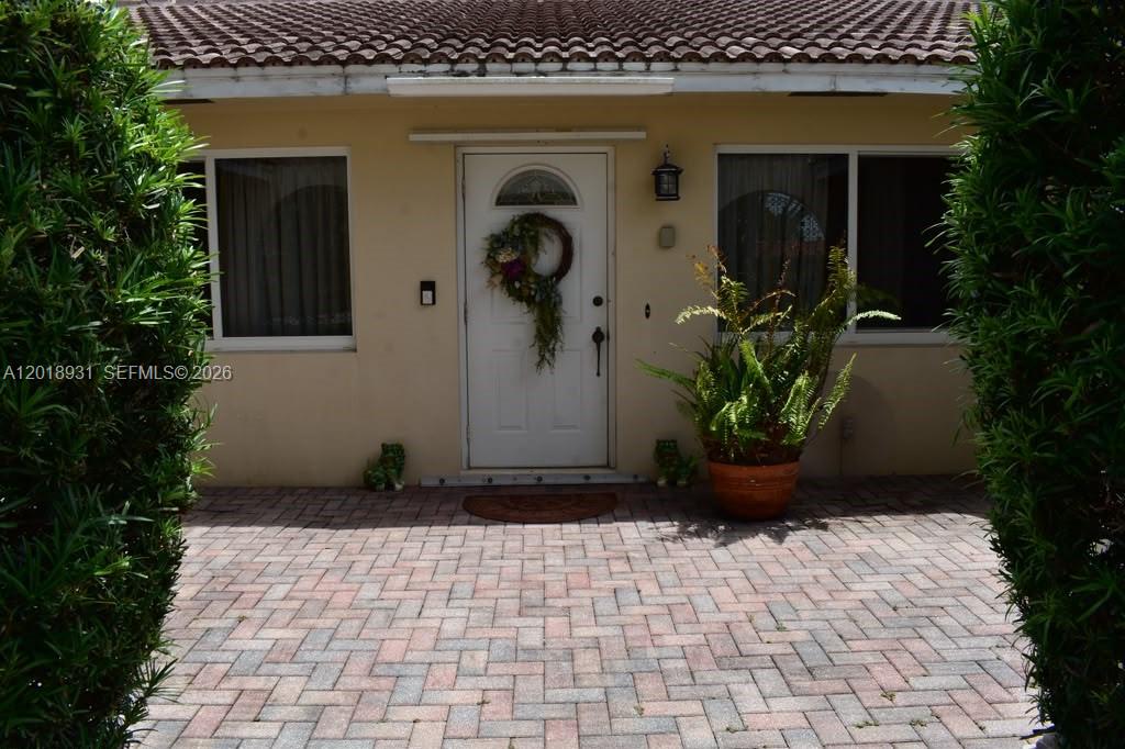 A paved walkway leads to the front entrance of a house with a white door — 3634 Lowson Blvd, Delray Beach FL 33445, DELRAY BEACH, FL