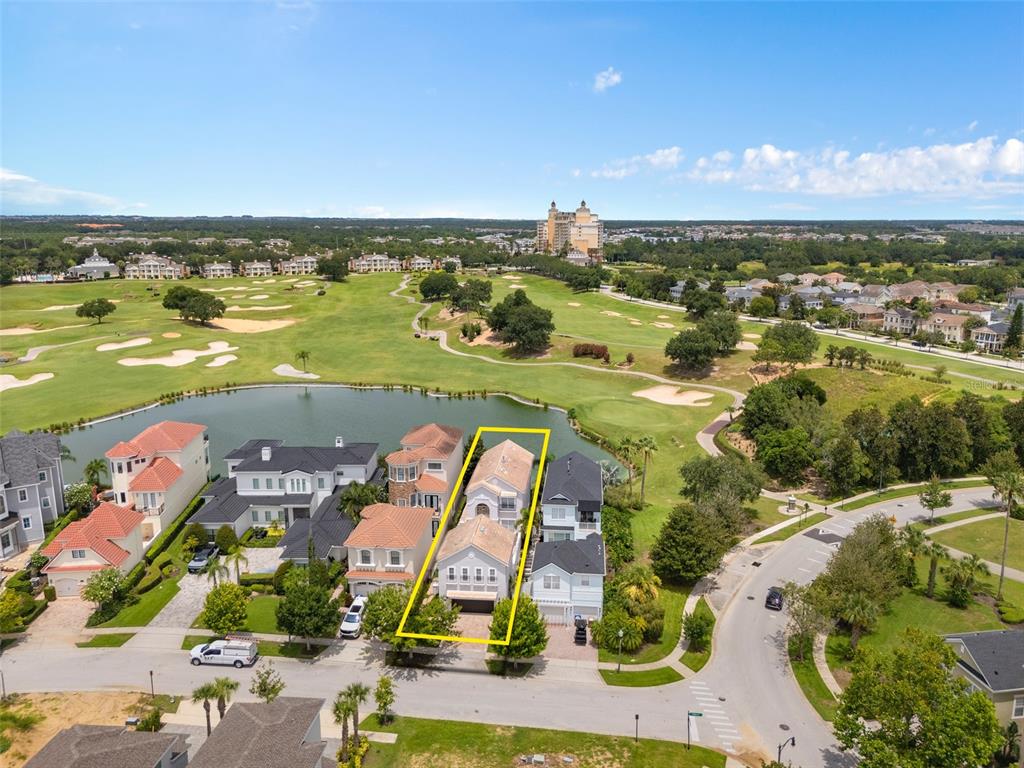An aerial view shows a residential house highlighted in yellow, situated near a golf course — 1402 TITIAN COURT, REUNION, FL