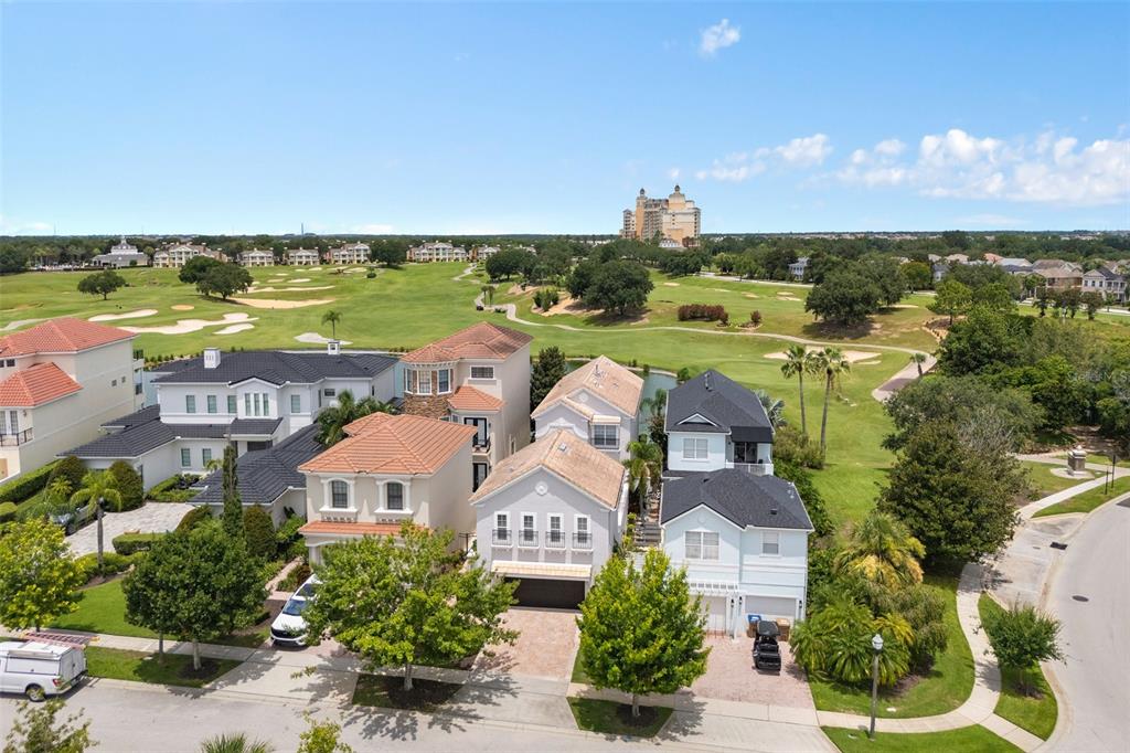 An aerial view shows several suburban houses bordering a golf course on a sunny day — 1402 TITIAN COURT, REUNION, FL