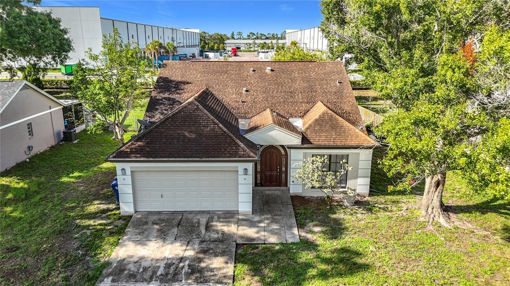 An aerial view shows a single-story house with a brown shingled roof and garage — 5664 25TH STREET CIRCLE E, BRADENTON, FL