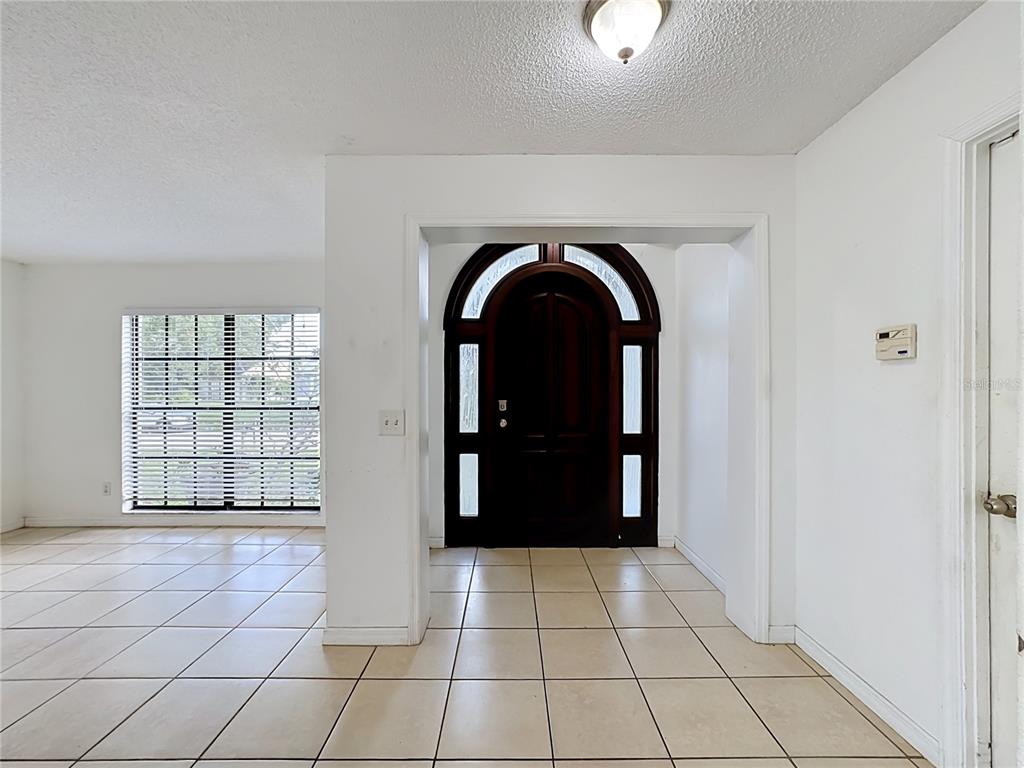 An entryway with tile flooring, a dark arched front door, and a white interior — 5664 25TH STREET CIRCLE E, BRADENTON, FL