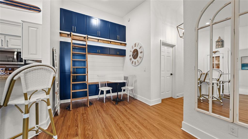 A dining area features blue cabinetry, a rolling library ladder, and a small bistro table — 13810 SUTTON PARK DRIVE N UNIT 1433, JACKSONVILLE, FL