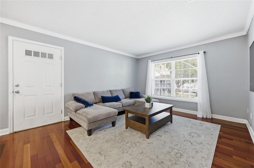 A living room features gray walls, hardwood floors, a gray sectional sofa, and a coffee table — 4888 CONWAY ROAD UNIT 70, ORLANDO, FL