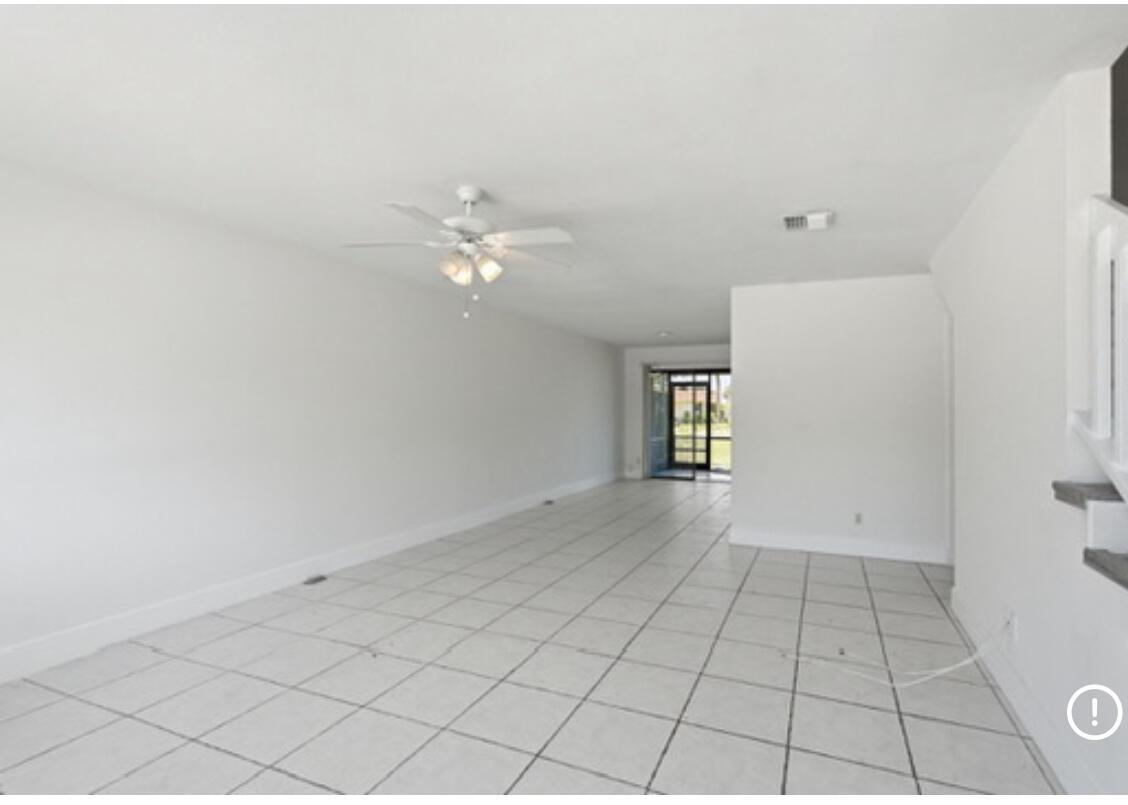 An empty living room with white walls, white tile flooring, and a ceiling fan — 4901 Pier Drive, FL 33463, FL