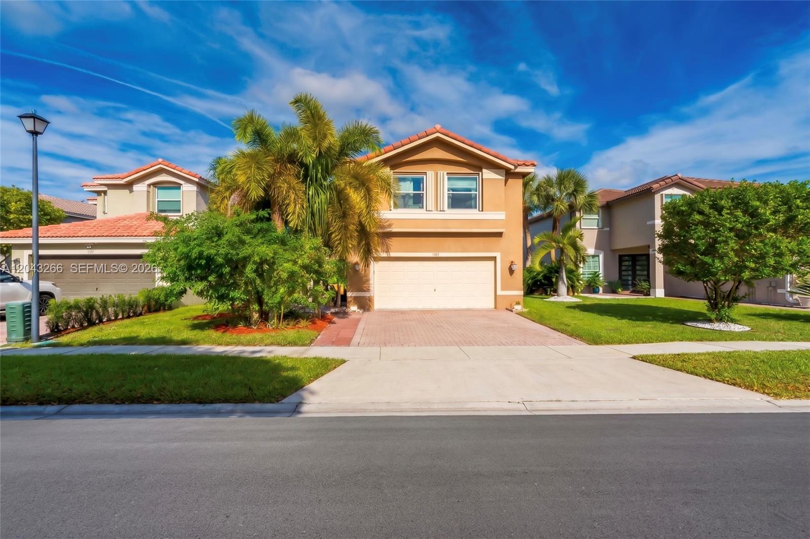 A two-story tan stucco house with a tiled roof and a paved driveway — 1941 SW 148th way, Miramar FL 33027, MIRAMAR, FL