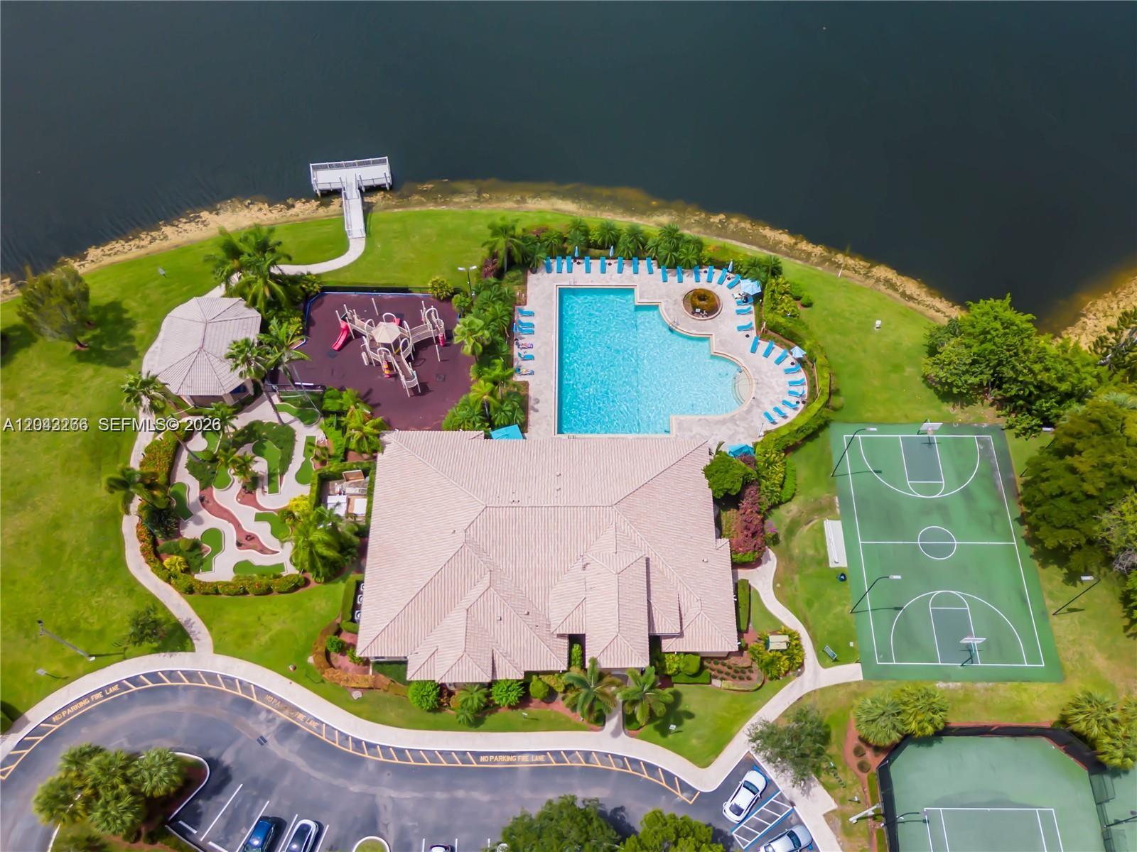 An aerial view shows a community clubhouse with a pool, playground, basketball court, and parking — 1941 SW 148th way, Miramar FL 33027, MIRAMAR, FL