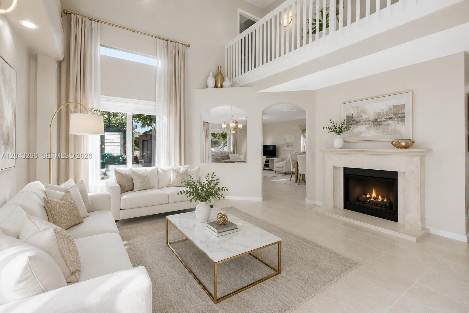 A bright living room features a fireplace, high ceilings, white sofas, and a marble coffee table — 1941 SW 148th way, Miramar FL 33027, MIRAMAR, FL