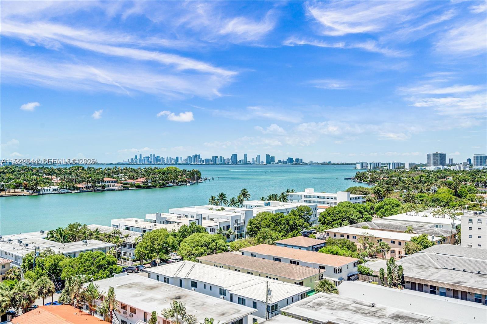 An elevated view shows a coastal neighborhood with low-rise buildings, lush trees, and a bay — 6900 Bay Dr # 7A, Miami Beach FL 33141, MIAMI BEACH, FL
