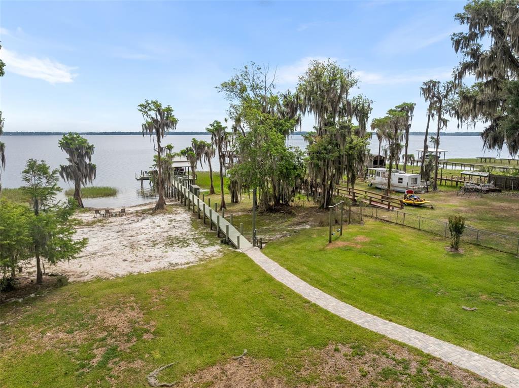 A boat dock with a covered slip, a pontoon boat, and a small dining set — 8026 NE 221ST STREET, MELROSE, FL