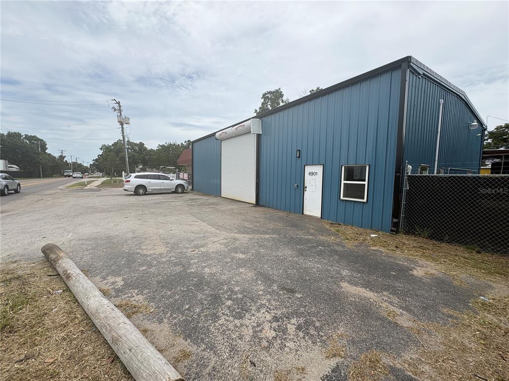 A blue metal warehouse building features a roll-up door, a pedestrian door, and a window — 6901 BENJAMIN ROAD, TAMPA, FL