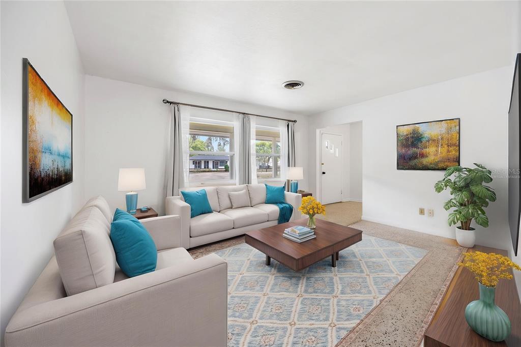 A living room features a beige sofa, a coffee table, and a patterned area rug — 4961 COUNTY ROAD 114, WILDWOOD, FL