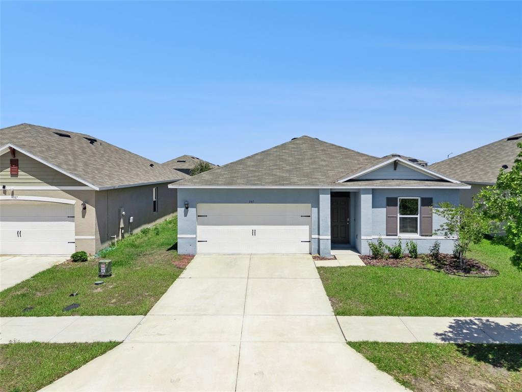 A single-story suburban house with a two-car garage and a concrete driveway — 391 BOARDWALK AVENUE, HAINES CITY, FL