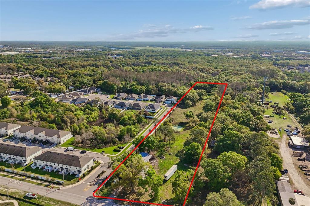 An aerial view shows a rectangular plot of land outlined in red near residential housing — 6213 ORIENT ROAD, TAMPA, FL