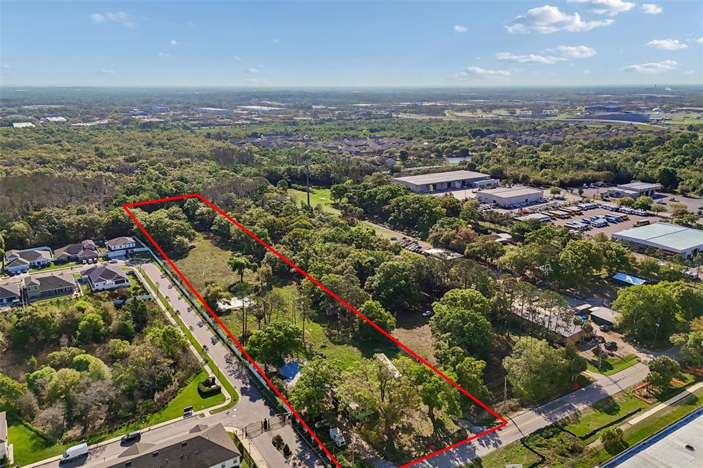 An aerial view shows a rectangular plot of land outlined in red near residential homes — 6213 ORIENT ROAD, TAMPA, FL