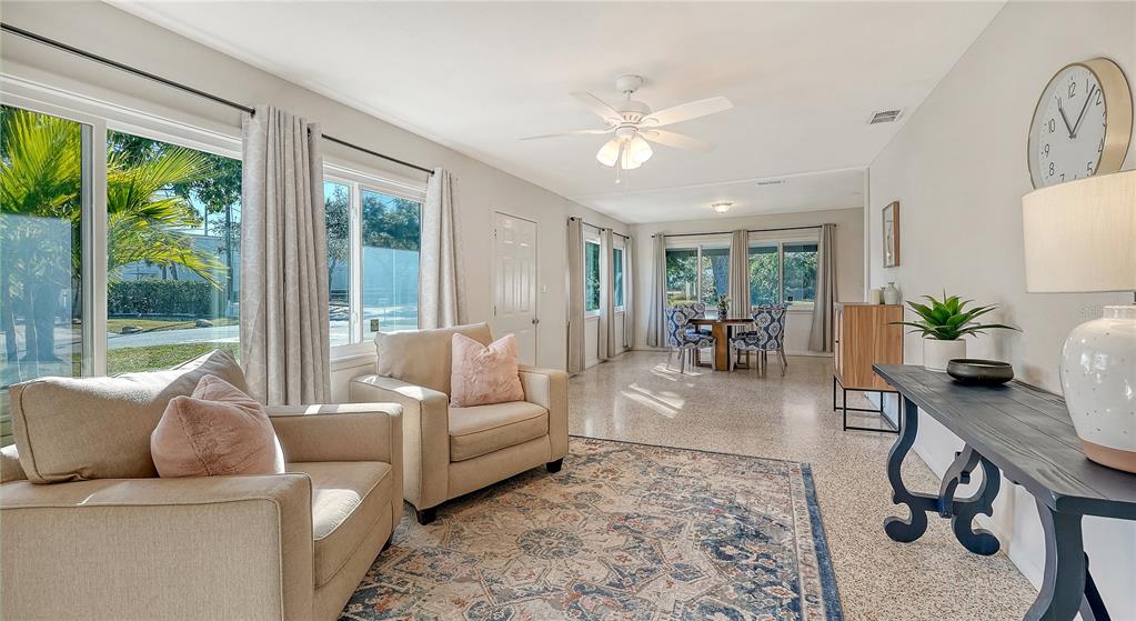 A living room features two beige armchairs, a patterned area rug, and a dining area — 209 BRIGGS COURT, SARASOTA, FL