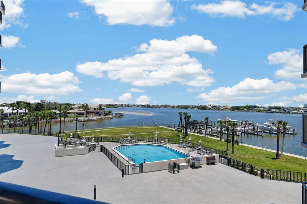 An elevated view of a swimming pool, lawn, and boat docks along a waterway — 503 N CAUSEWAY UNIT 2020, NEW SMYRNA BEACH, FL