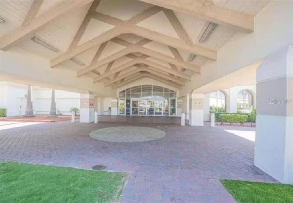 A covered brick driveway leads to the glass-paned entrance of a building with exposed beams — 2700 N ATLANTIC AVENUE UNIT 415, DAYTONA BEACH, FL