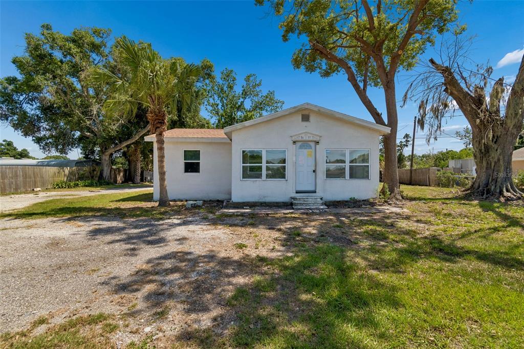 A single-story white house with a gabled roof sits on a large, grassy lot — 1611 E SHELL POINT ROAD, RUSKIN, FL