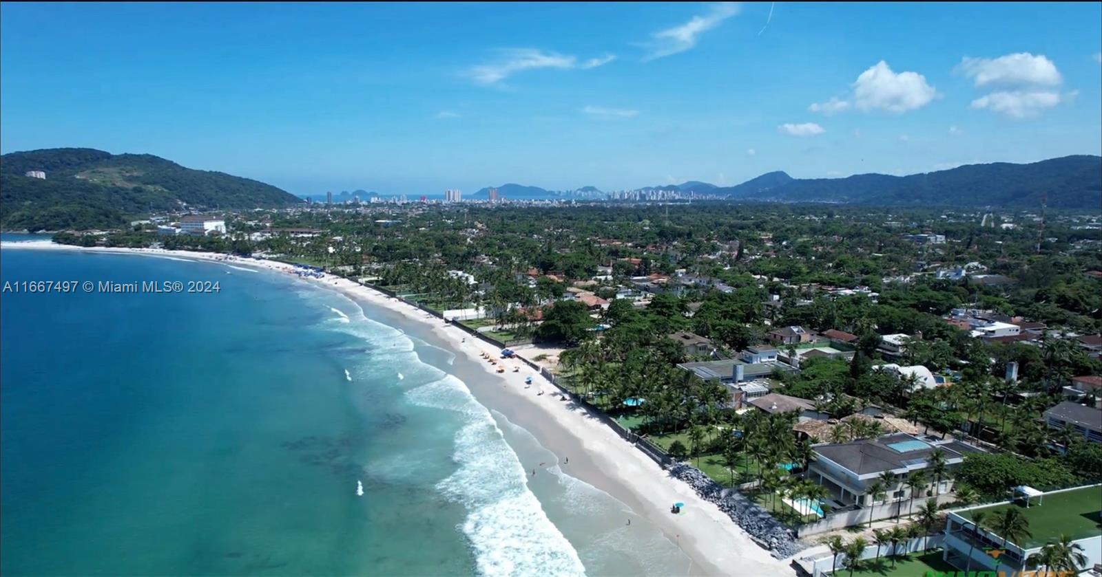 An aerial view of a sandy beach coastline with lush vegetation and residential properties — 198 Passeio ave, SP 11444-380, SP