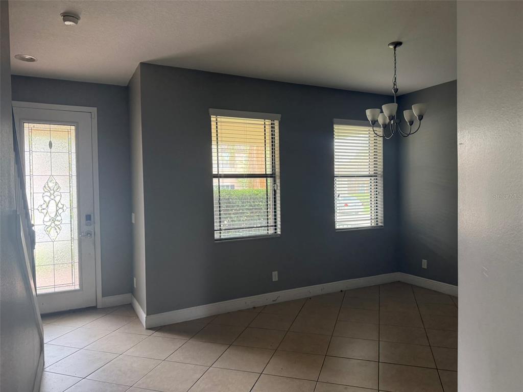 A dining area features gray walls, tile flooring, two windows with blinds, and a chandelier — 1863 ALTAVISTA CIRCLE, LAKELAND, FL