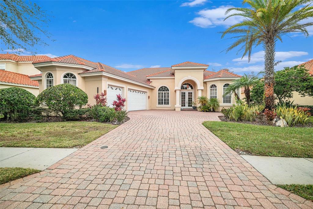A single-story stucco house with a tiled roof and a paved driveway — 8478 DUNHAM STATION DRIVE, TAMPA, FL