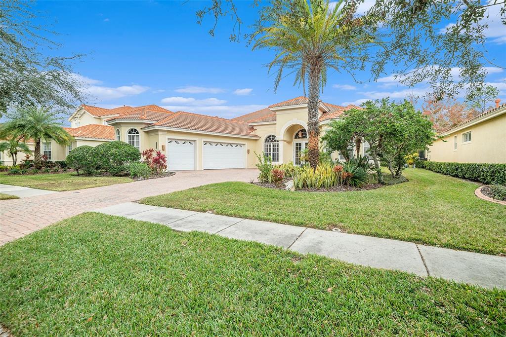 A single-story house with a tile roof, two-car garage, and a palm tree in front — 8478 DUNHAM STATION DRIVE, TAMPA, FL