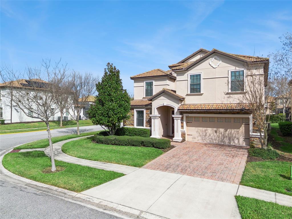 A two-story stucco house with a tiled roof and a brick driveway — 1430 MOON VALLEY DRIVE, DAVENPORT, FL