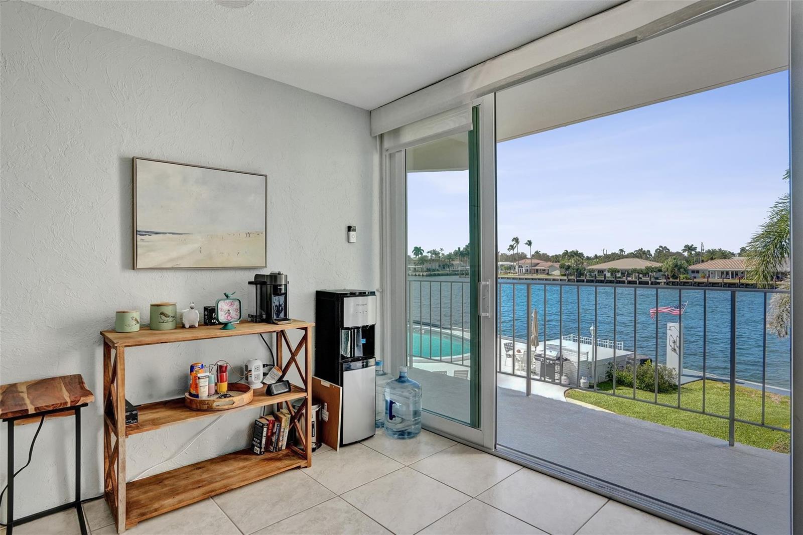 A room with tile flooring, a wooden shelving unit, and a sliding door to a balcony — 801 N Riverside Drive # 4b, Pompano Beach FL 33062, POMPANO BEACH, FL