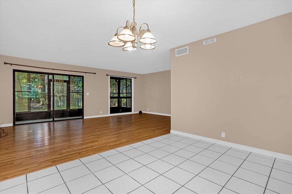 A room with white tile flooring transitioning to hardwood, a chandelier, and sliding glass doors — 411 SHEOAH BOULEVARD UNIT 43, WINTER SPRINGS, FL