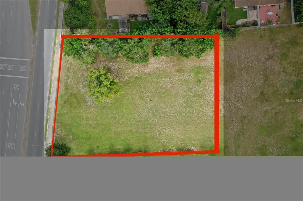 An aerial view shows a rectangular, grass-covered vacant lot outlined in red — OLD WINTER GARDEN ROAD, ORLANDO, FL