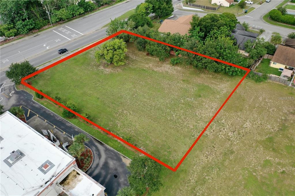 An aerial view shows a vacant, rectangular grass lot outlined in red next to a road — OLD WINTER GARDEN ROAD, ORLANDO, FL