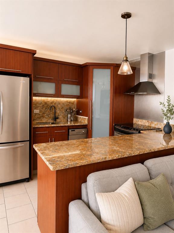 A kitchen with wood cabinets, granite countertops, and stainless steel appliances overlooks a gray sofa — 1305 MAGDALENA AVENUE UNIT 10B, SAN JUAN, PR